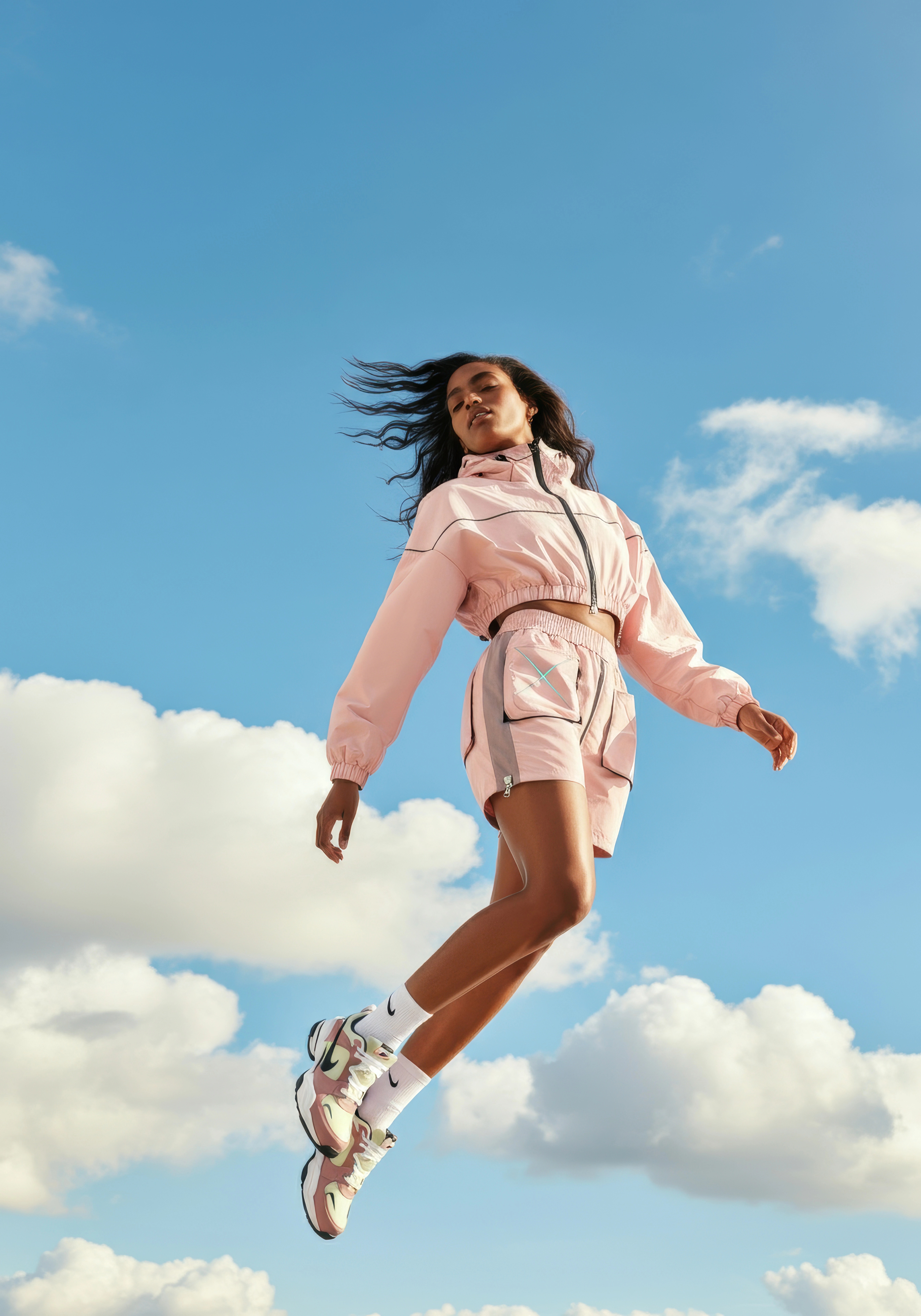 Woman jumping in the air against blue sky